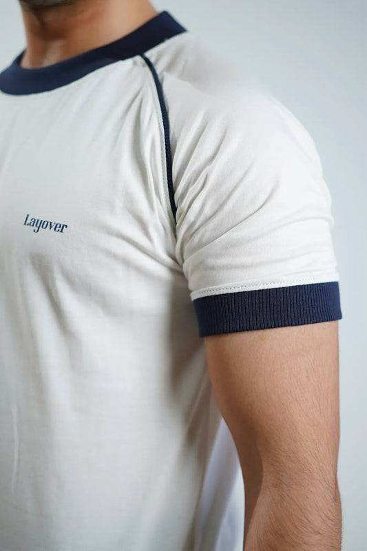 Close-up of a person wearing a white t-shirt with navy blue accents and 'Layover' branding.