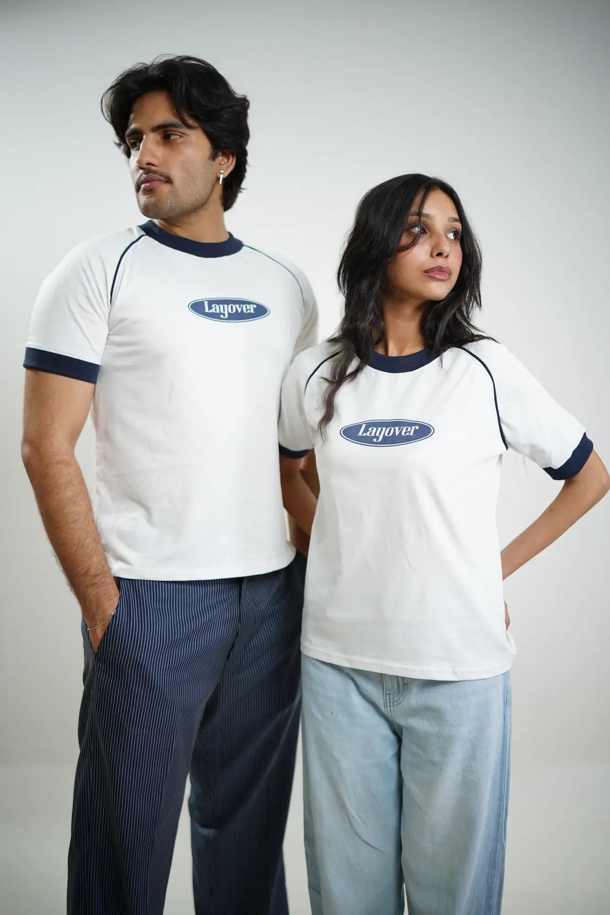 Two people wearing white t-shirts with 'Layover' logo on a plain white background